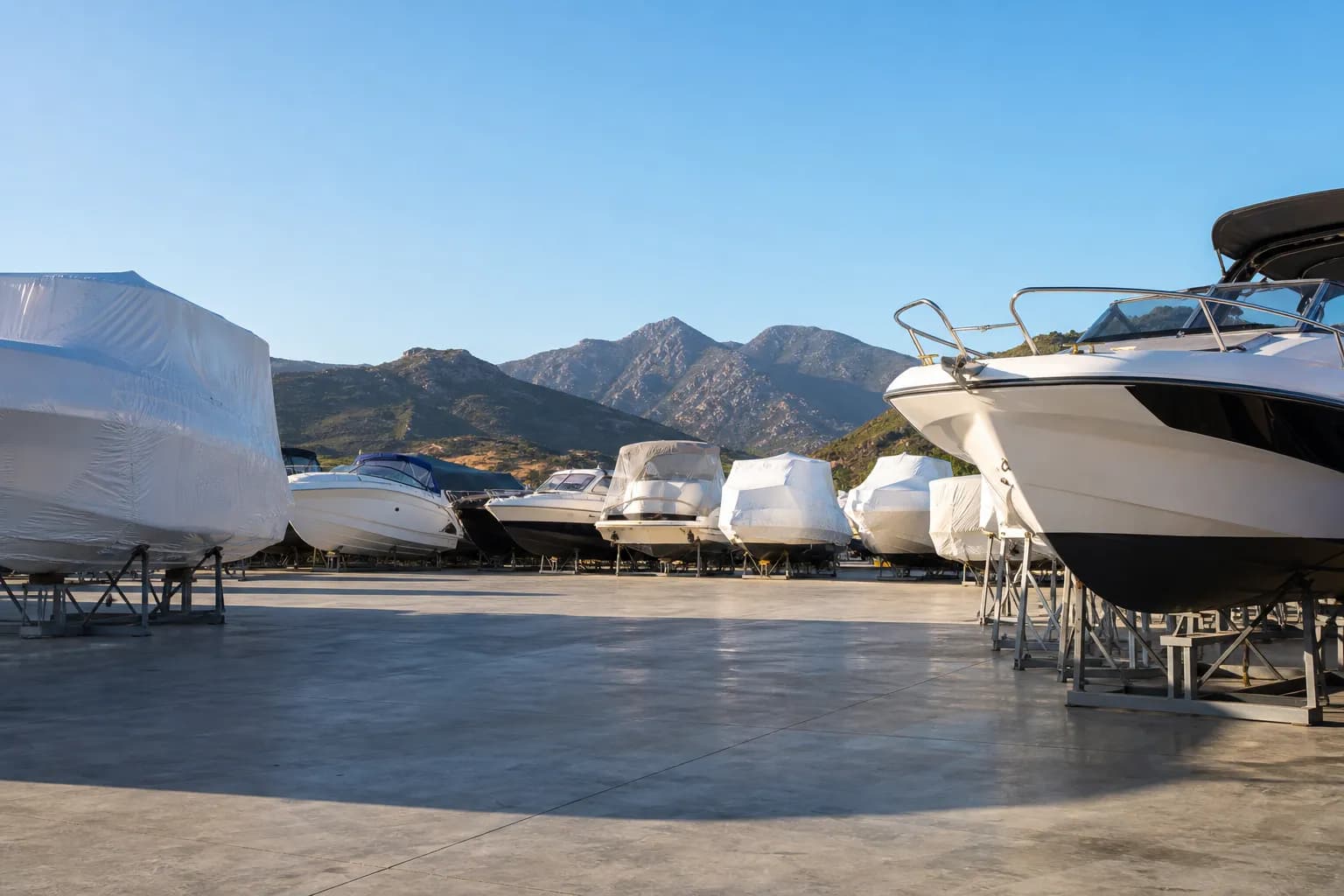 Bateaux à moteur hivernés sur ber et sous cocon dans un parc à Calvi